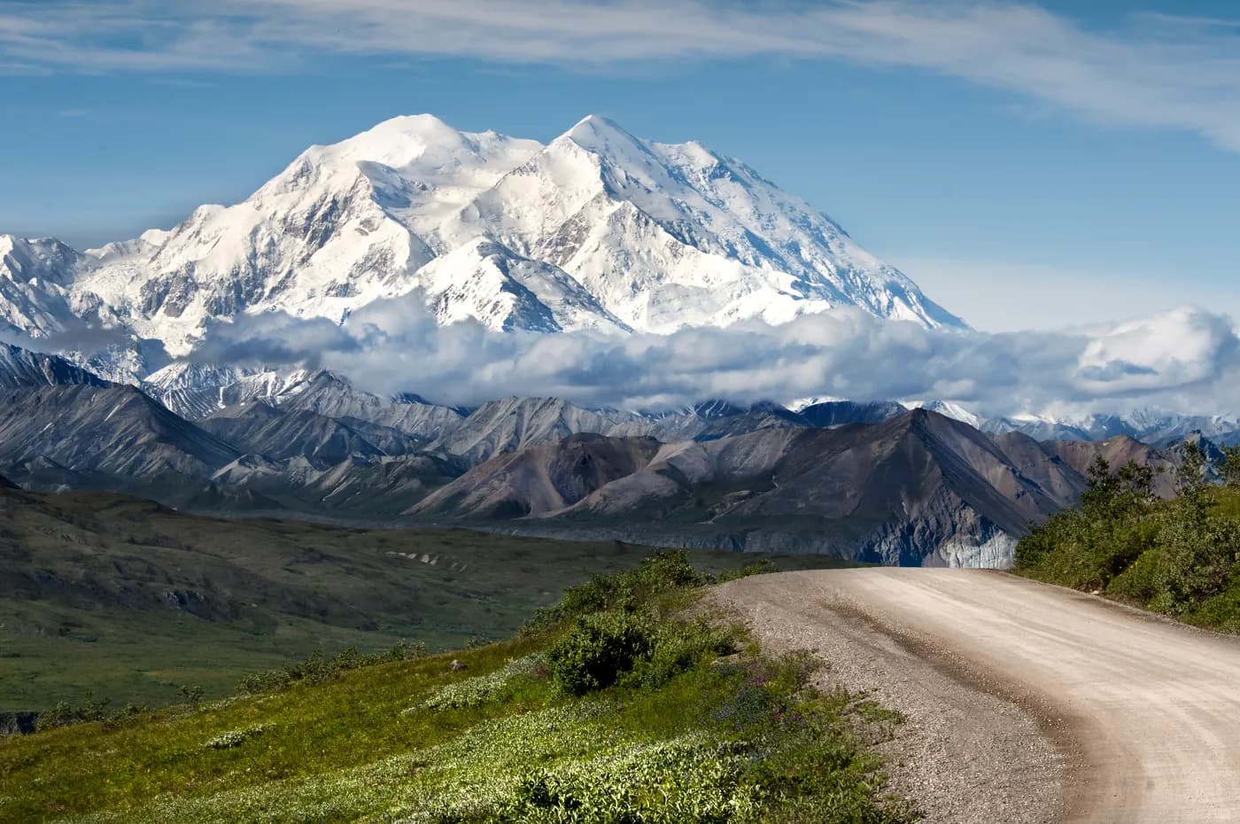 Snow-covered Denali beyond a winding park road